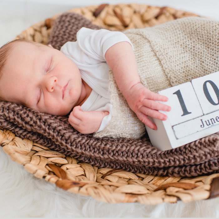 Neugeborenes beim Fotoshooting mit Kalender des Geburtstages
