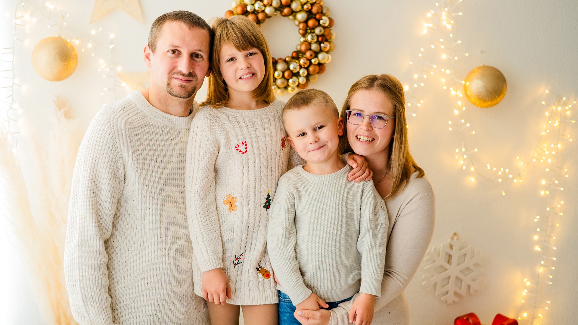 Family with two children in front of Christmas decorations in the studio