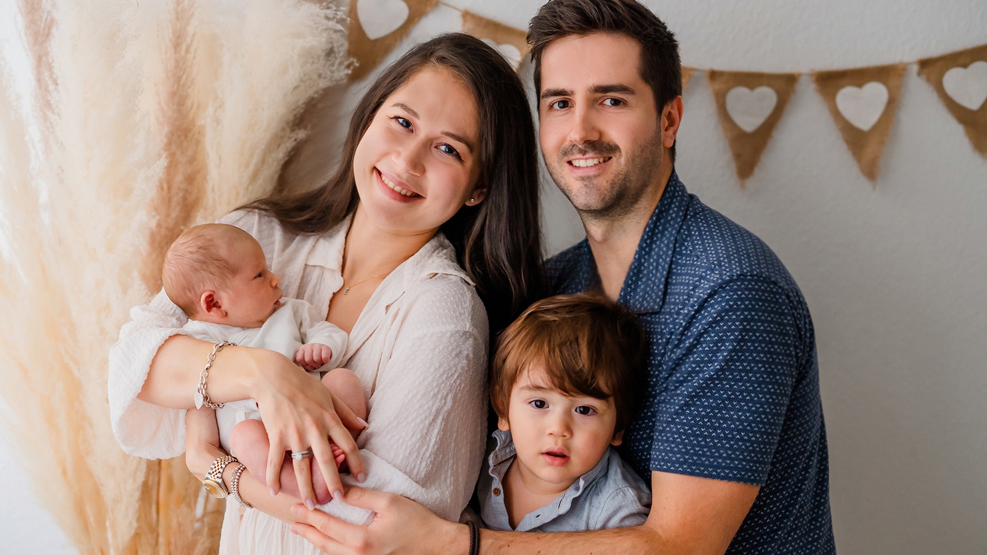 Parents with a newborn baby and an older child in the photography studio