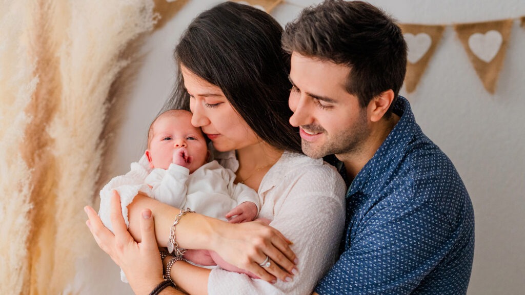 Mama und Papa halten das Baby im Arm im Fotostudio