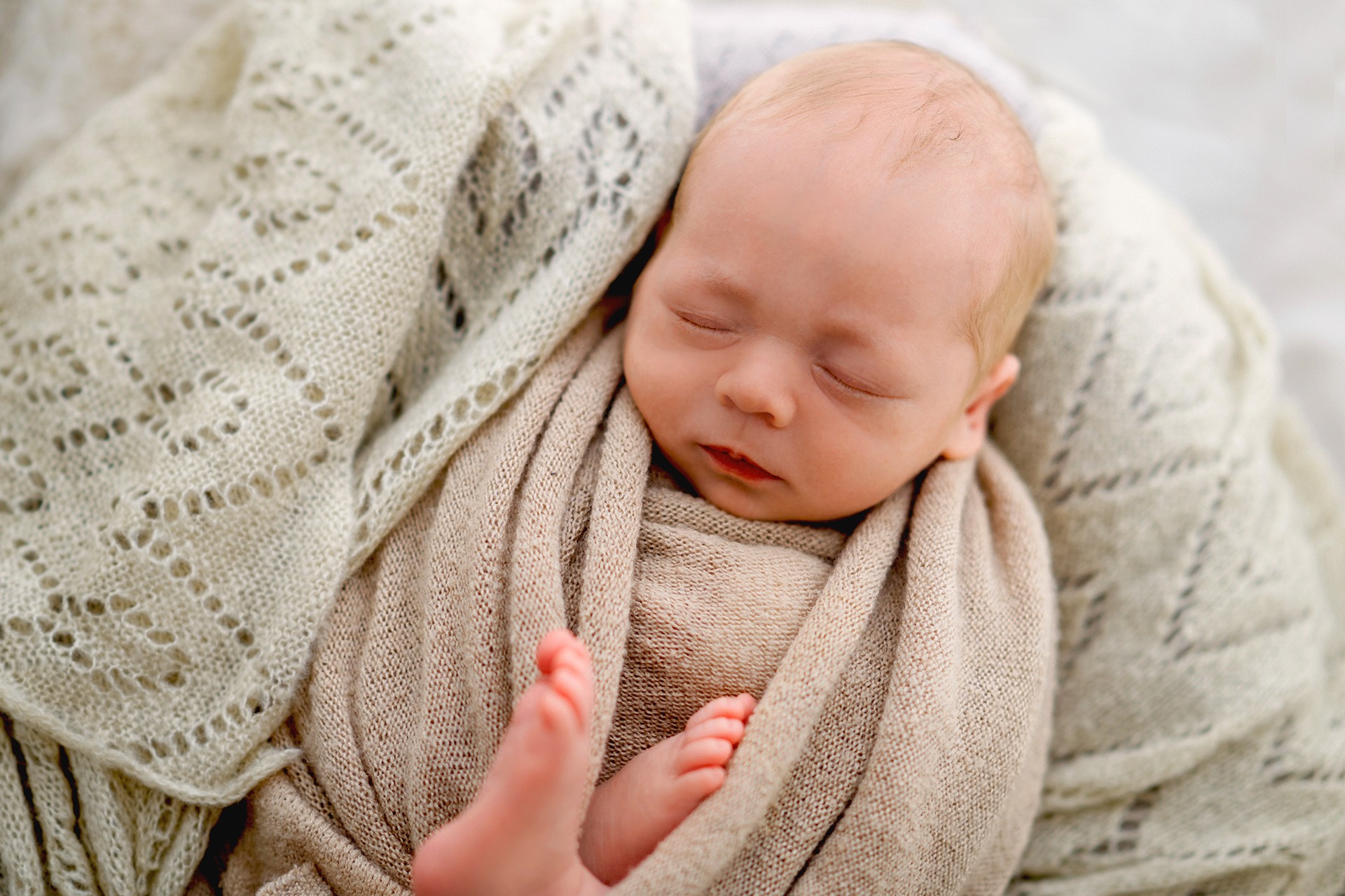 Neugeborenes Baby im Strick gemütlich gewrappet