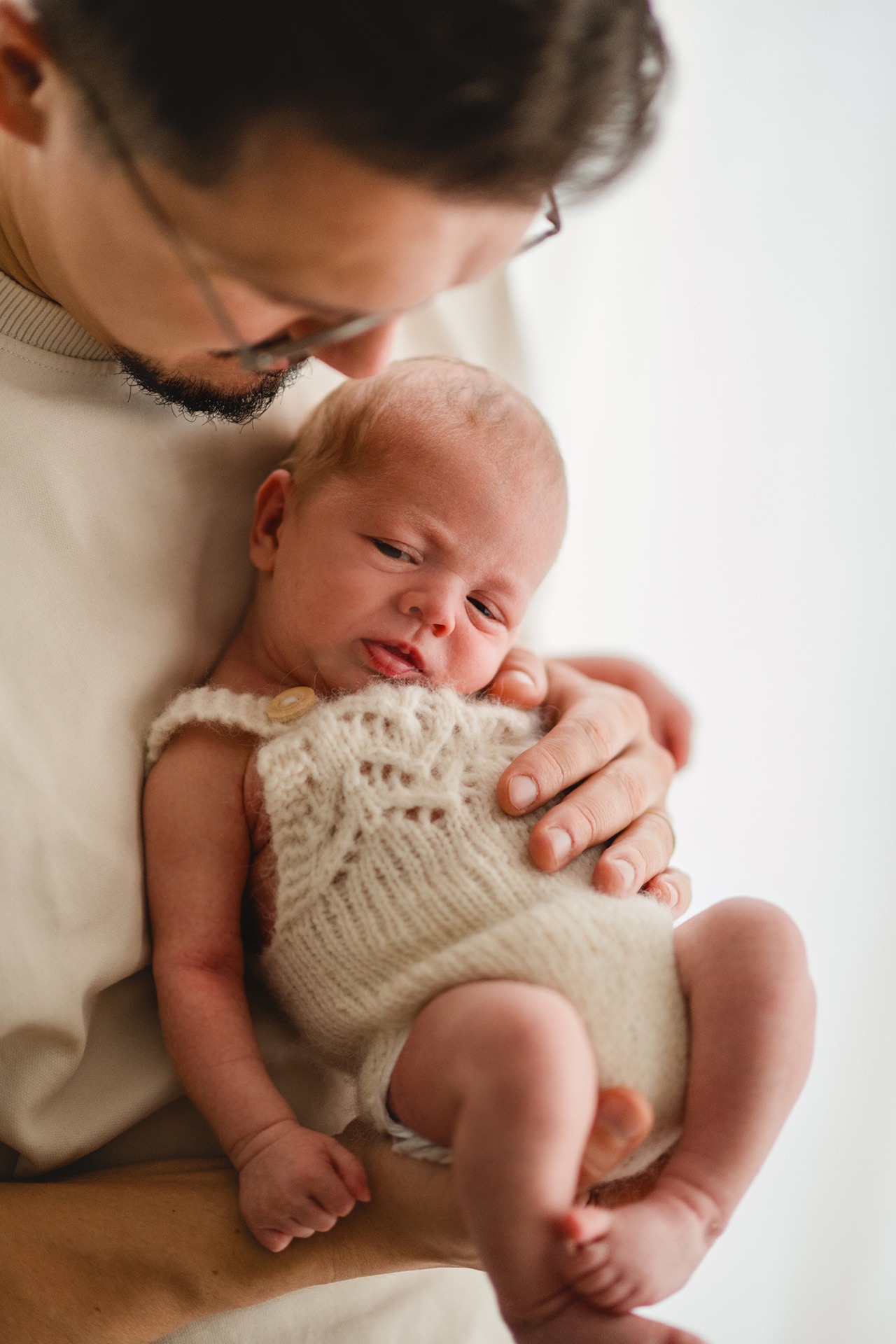 Papa hält Babyjungen auf dem Arm bei einem Homeshooting